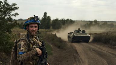 Ukraine-Krieg - Soldat in Bachmut steht vor Schützenpanzer, Archivbild
