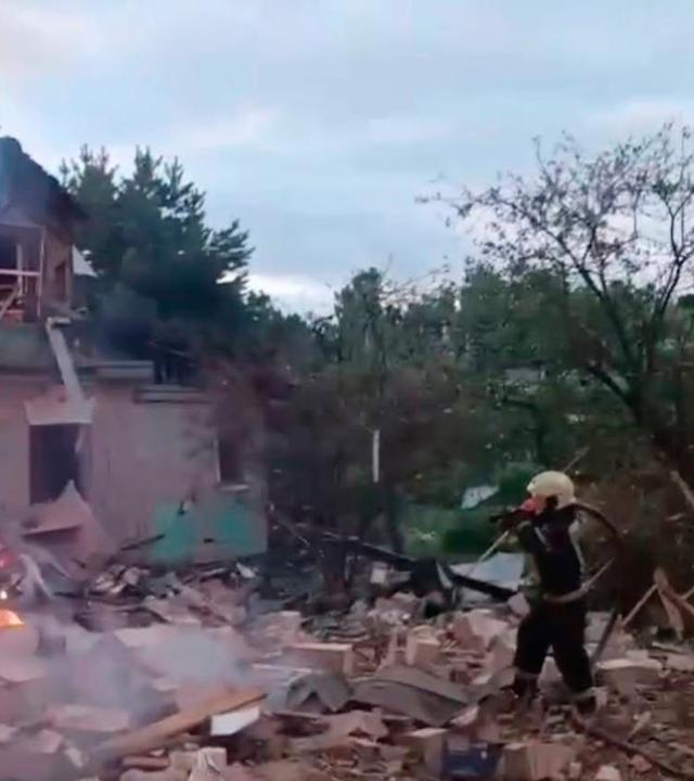 Russland: Ein Feuerwehrmann bei der Löscharbeiten an einem Haus, das von den Drohnenangriffen der Ukraine getroffen wurde.