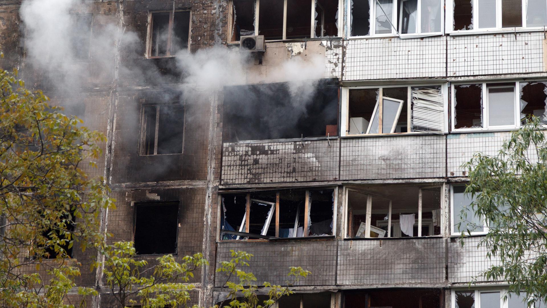 Rauch steigt aus einem brennenden Wohnblock in der Ukraine auf, der durch herabfallende russische Drohnentrümmer beschädigt wurde.