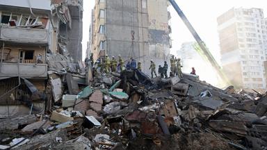 Rettungskräfte des staatlichen Rettungsdienstes räumen am 14. Mai 2026 in Kiew (Ukraine) Trümmer an einem neunstöckigen Wohnblock beiseite, der durch einen russischen Raketen- und Drohnenangriff beschädigt wurde. 