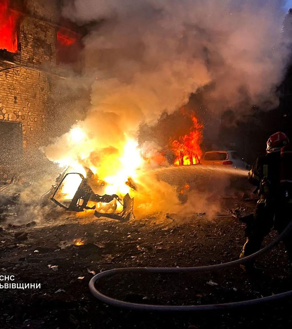 Ukraine, Lwiw: Feuerwehr löscht ein brennendes Auto nach russichen Luftangriffen.