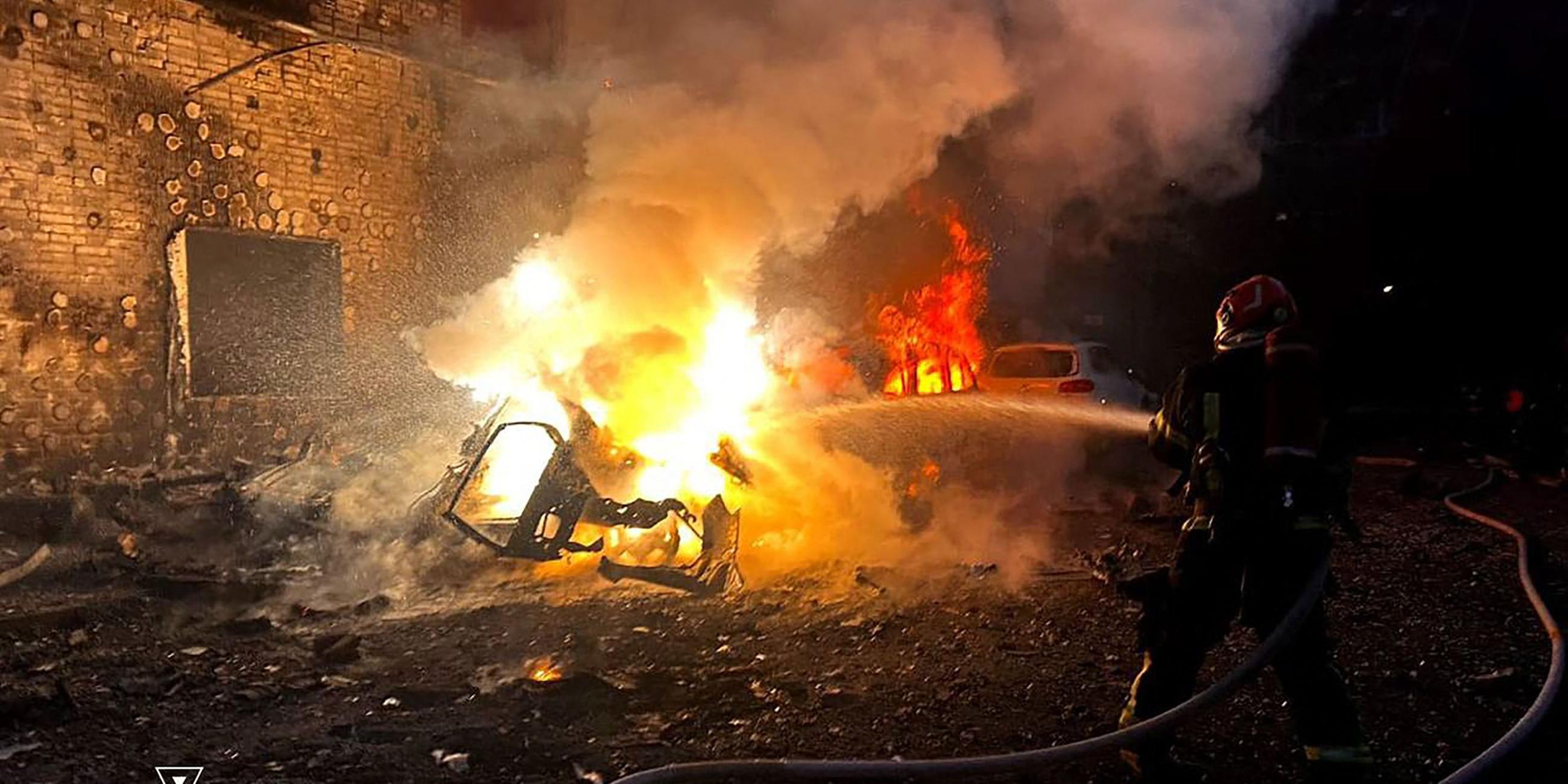 Ukraine, Lwiw: Feuerwehr löscht ein brennendes Auto nach russichen Luftangriffen.