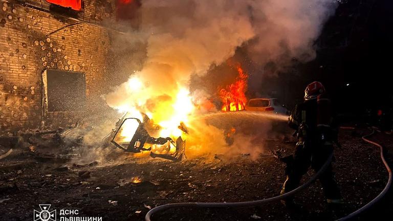 Ukraine, Lwiw: Feuerwehr löscht ein brennendes Auto nach russichen Luftangriffen.