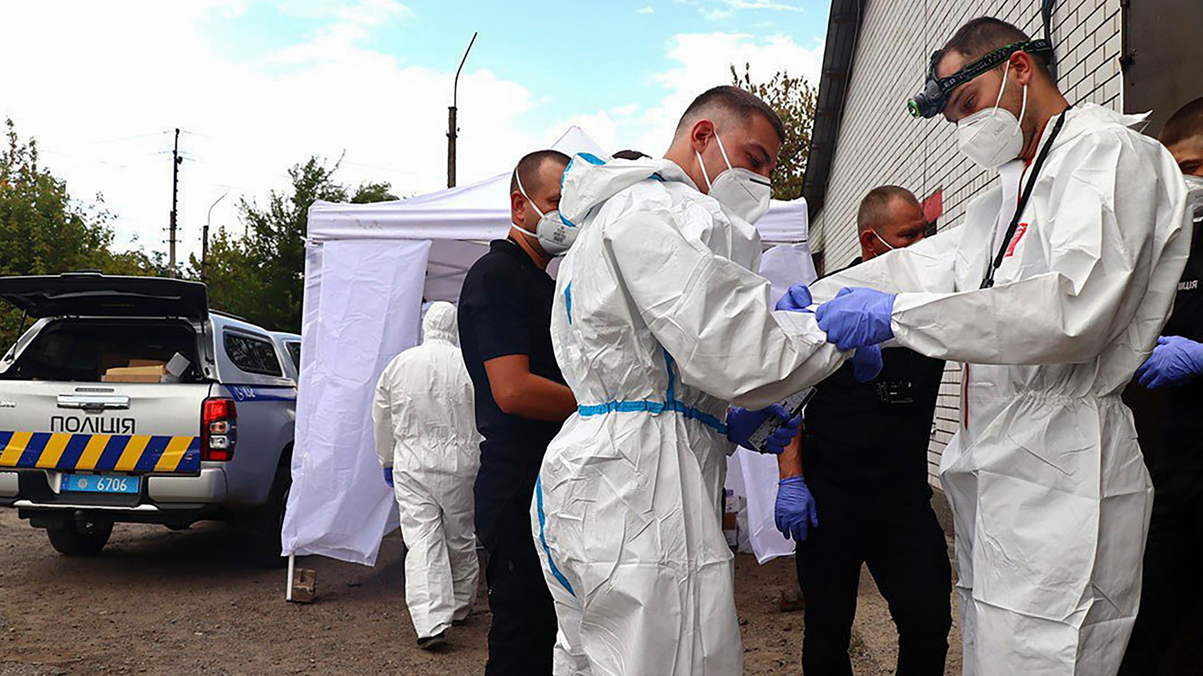 Ein von der ukrainischen Nationalpolizei bereitgestelltes Handout-Foto zeigt ukrainische Forensiker beim Anlegen ihrer Schutzausrüstung, bevor sie Opfer nach einem russischen Luftangriff auf das Dorf Jarowa in der Region Donezk (Ukraine) am 9. September 2025 untersuchen, inmitten der anhaltenden russischen Invasion. 