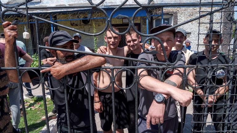 Gefangene stehen hinter dem Zaun im Kasernenhof eines Gefängnisses in der Region Dnipropetrowsk (Ukraine) am 21.06.2024