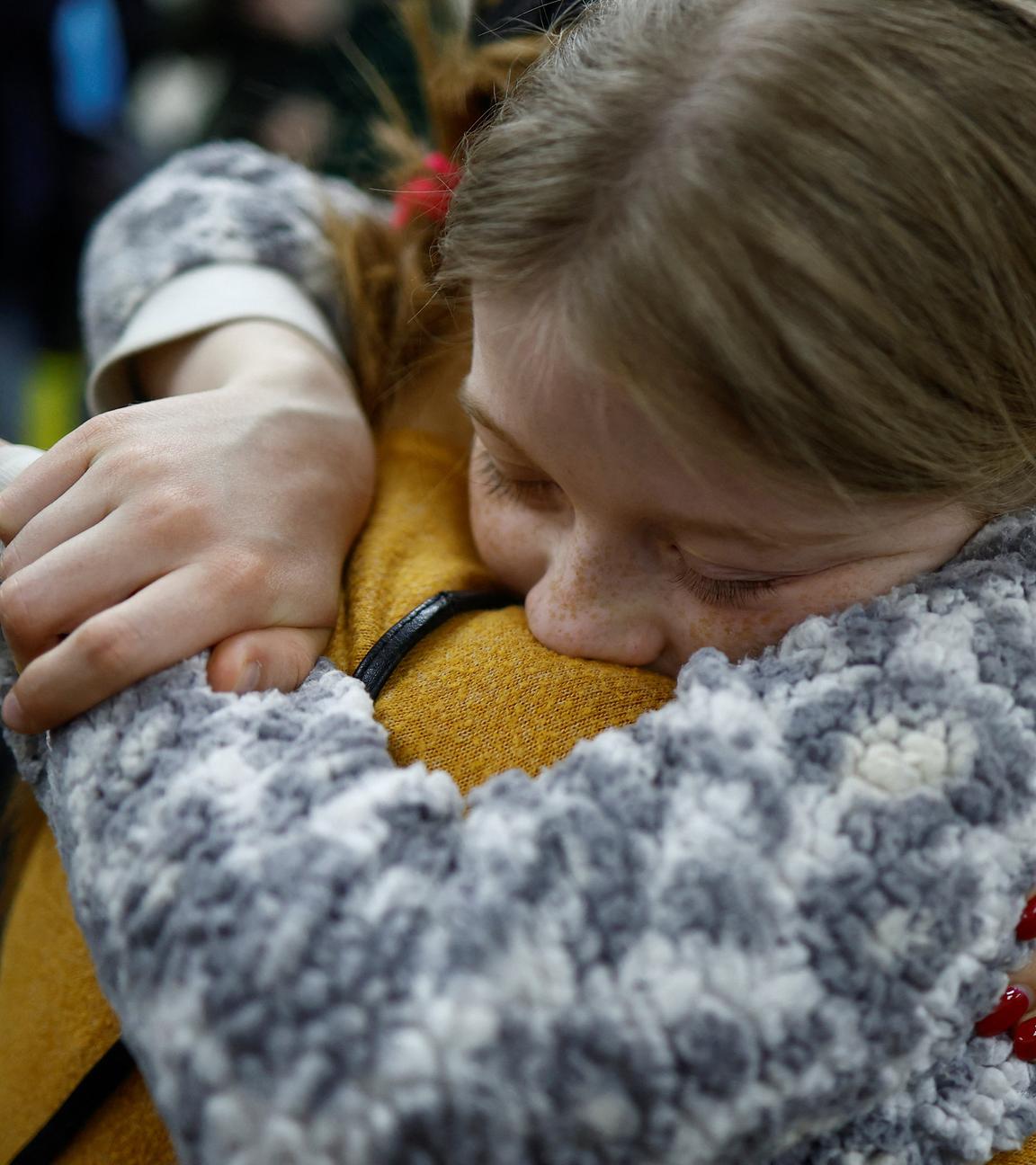 Eine Mutter umarmt ihre Tochter, die zuvor nach Russland verschleppt worden war.