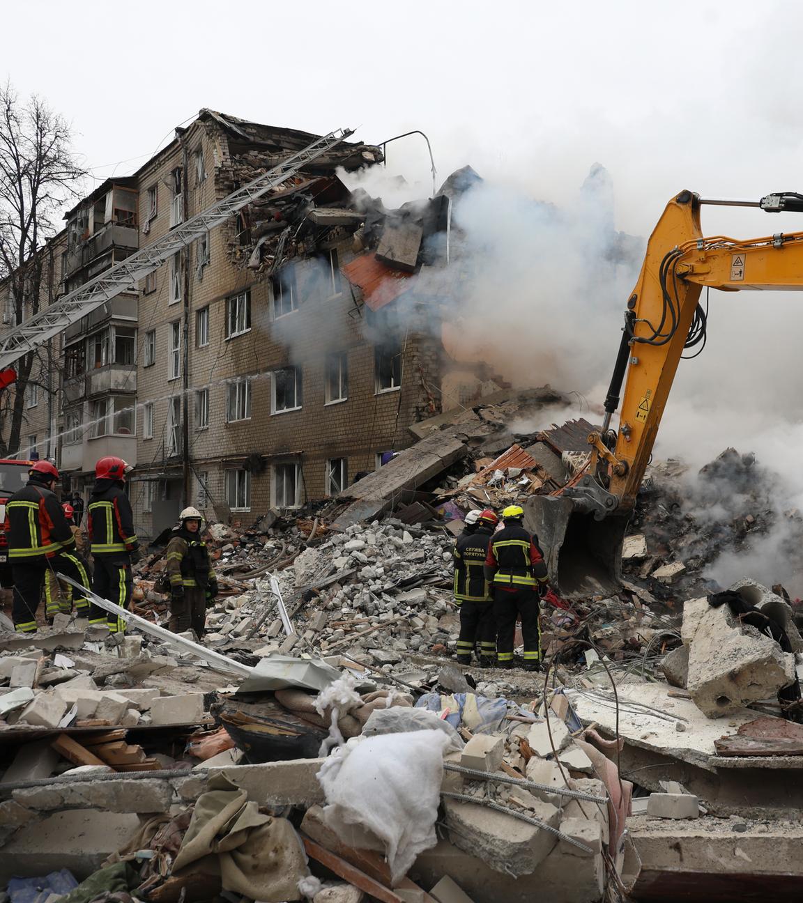 Ukrainische Rettungsmitarbeiter bei einem Wohngebäude in Charkiw, das von einem russischen Angriff getroffen wurde.