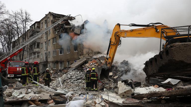 Ukrainische Rettungsmitarbeiter bei einem Wohngebäude in Charkiw, das von einem russischen Angriff getroffen wurde.