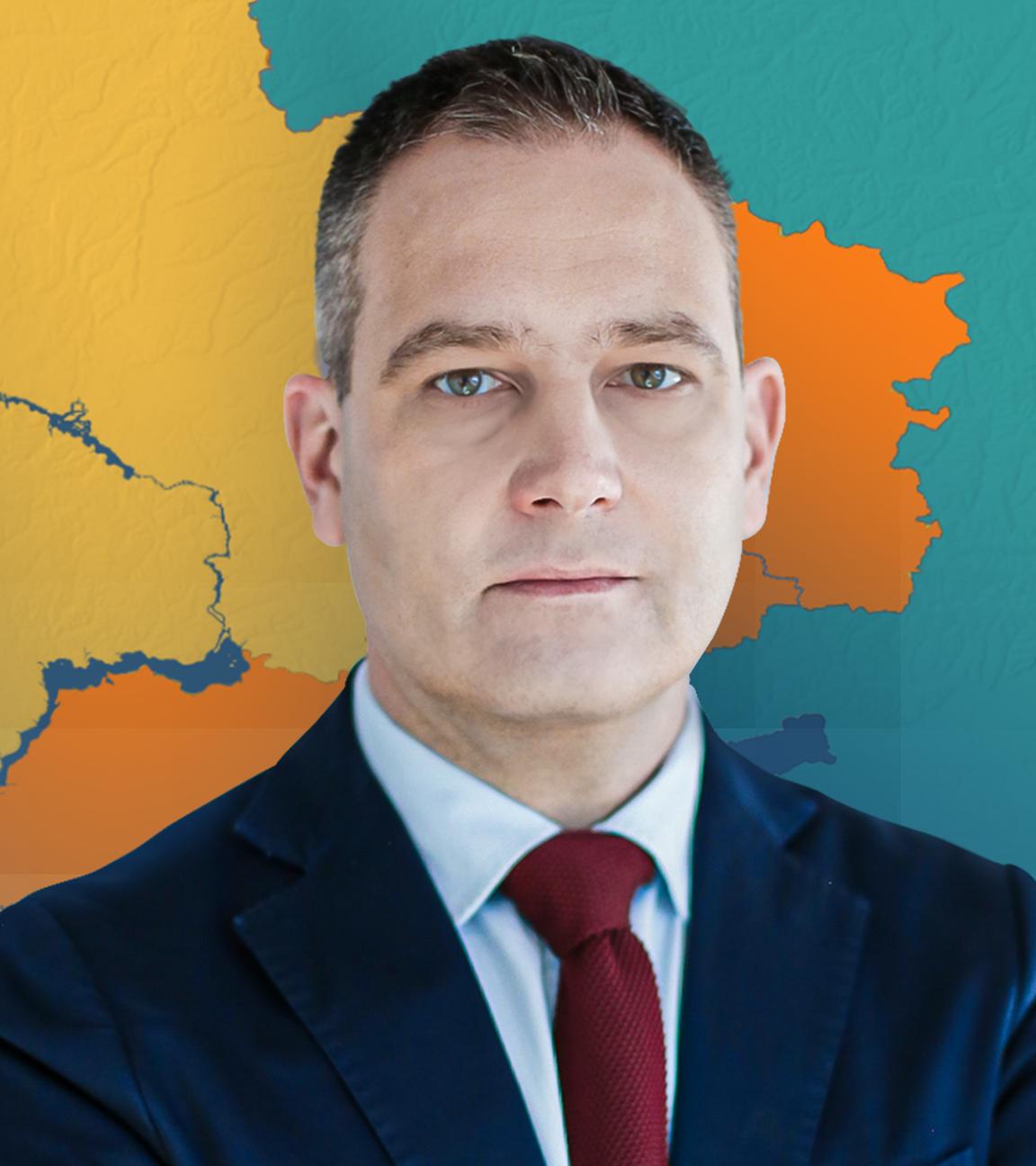 Militärexperte gustav gressel im Anzug vor einer Karte der Ukraine