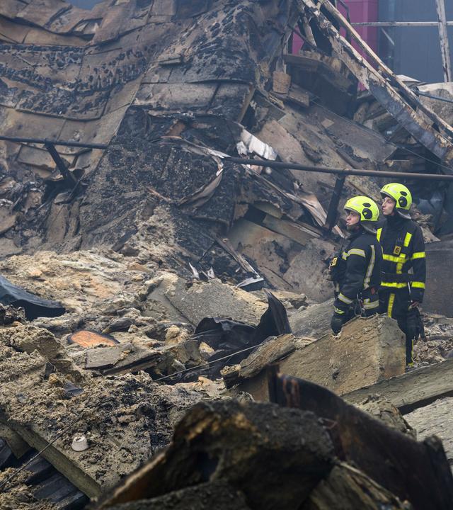 Ukrainische Rettungskräfte sind am Ort eines russischen Raketeneinschlags in einen Hypermarkt in Kiew im Einsatz,