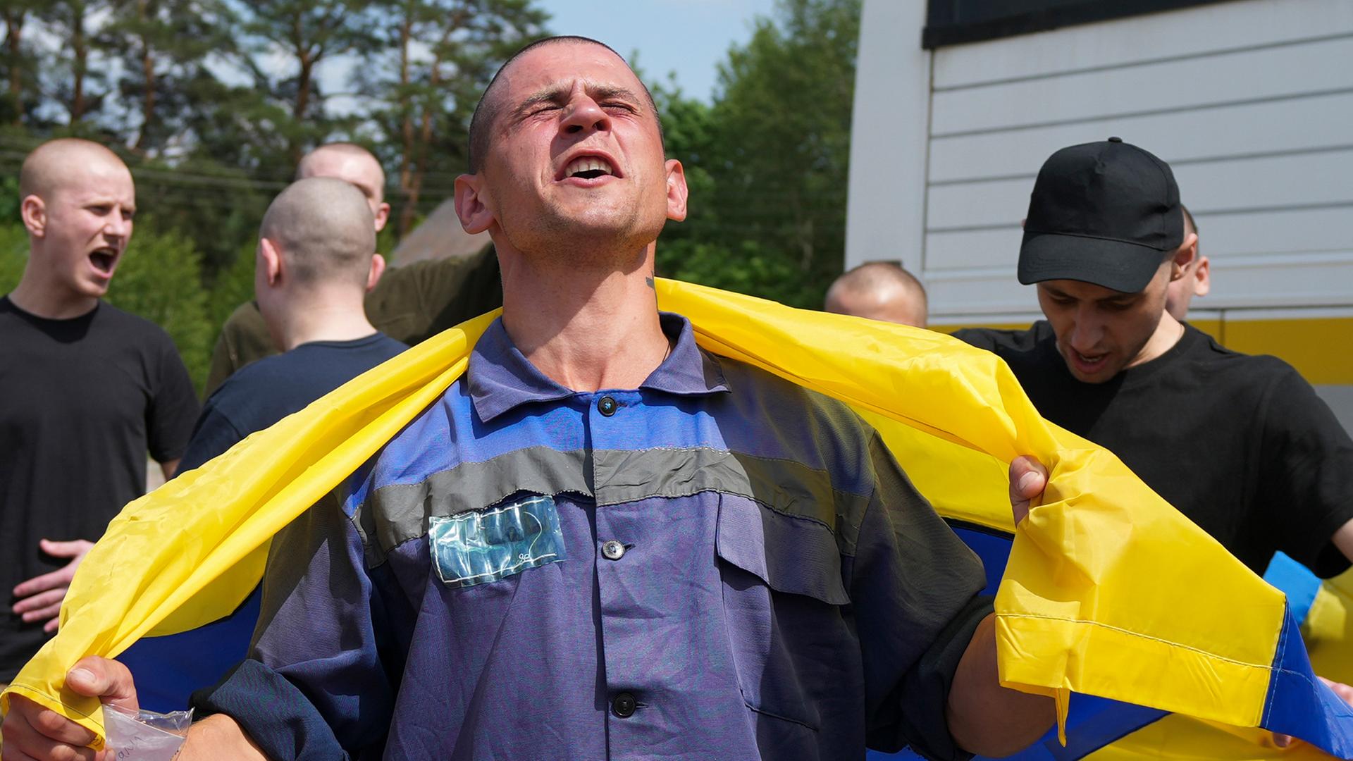 Ukrainische Kriegsgefangene posieren mit Fahnen nach einem Gefangenenaustausch mit Russland an einem ungenannten Ort, Ukraine, 09. Juni 2025.