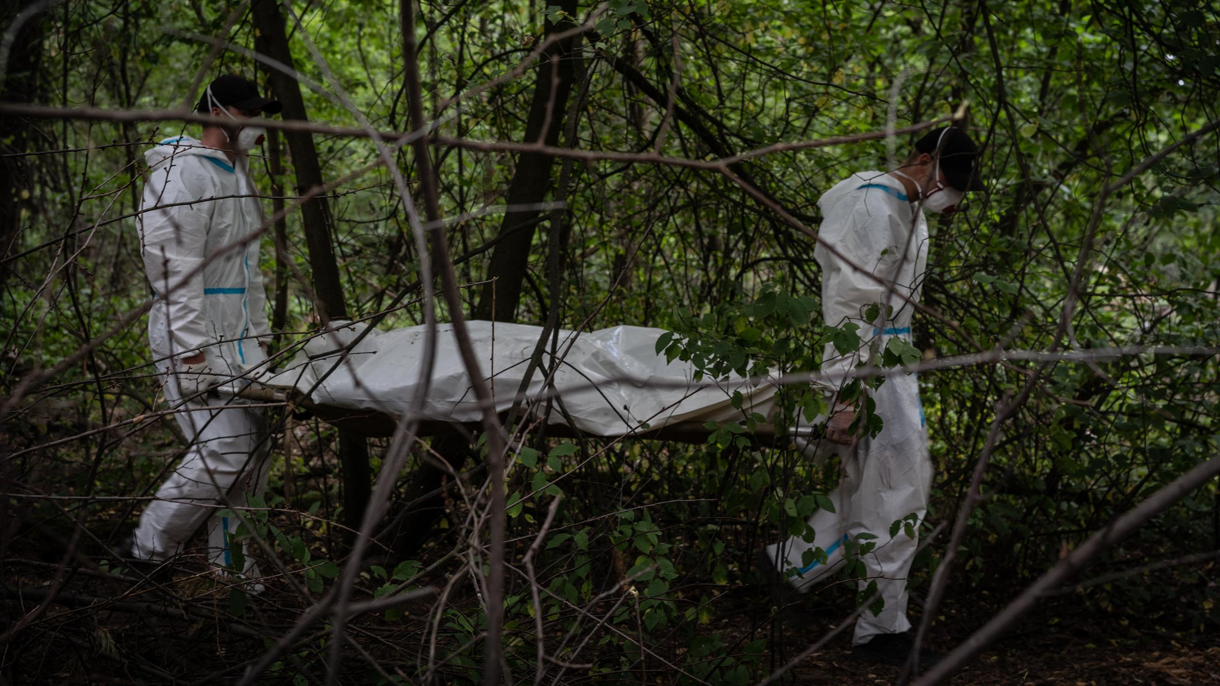 Eine Frau in dicker Jacke hält ein Kind fest in ihren Armen.