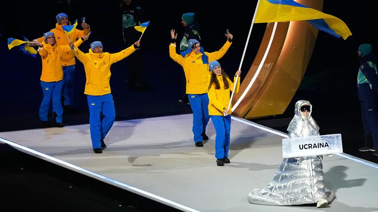 Anastasia Kutscherowa trägt das Schild, als sie die Athleten aus der Ukraine bei der Eröffnungsfeier der Olympischen Winterspiele in die Arena führt.