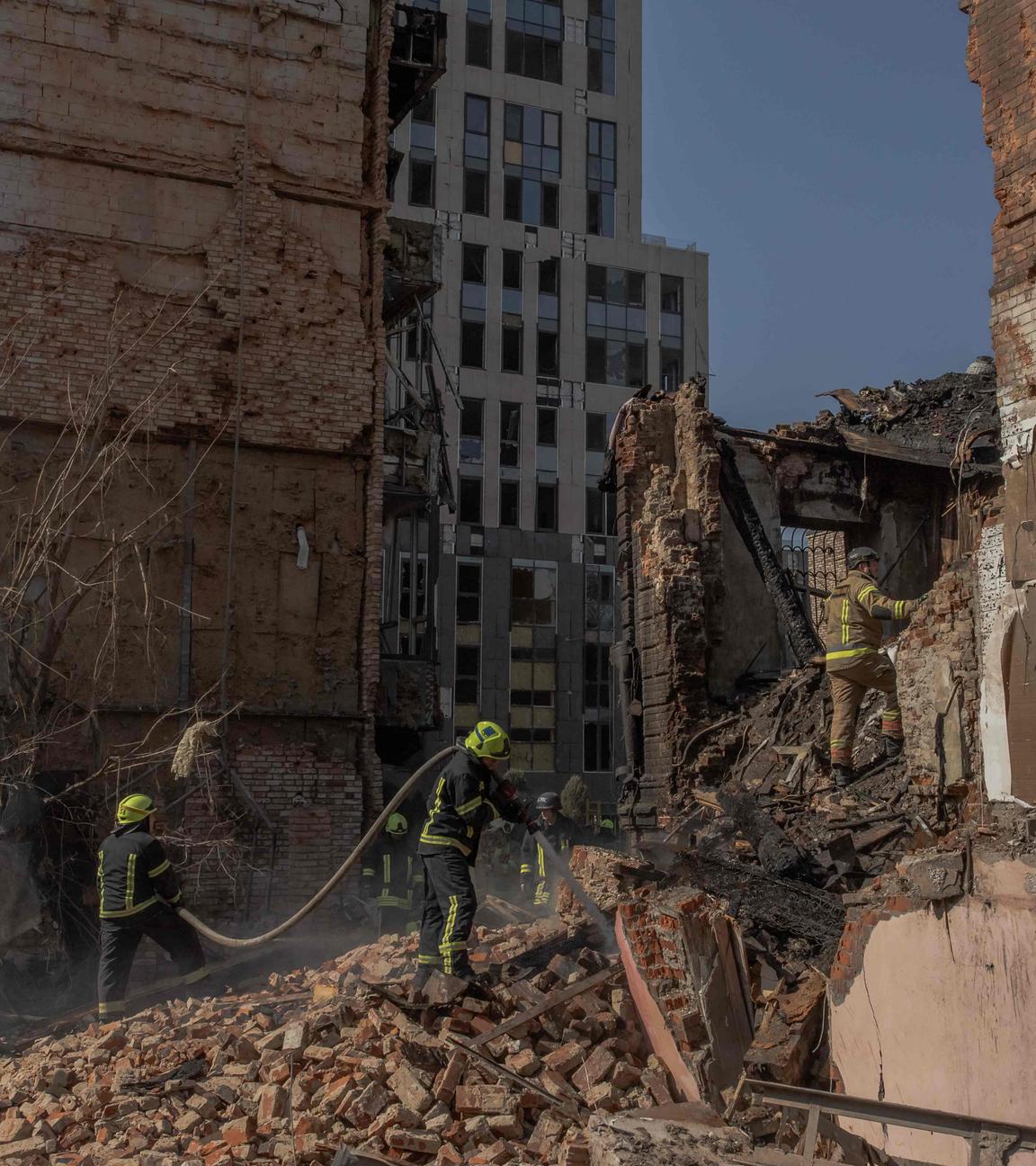 Ukrainische Rettungskräfte arbeiten an einem schwer beschädigtem Gebäude.