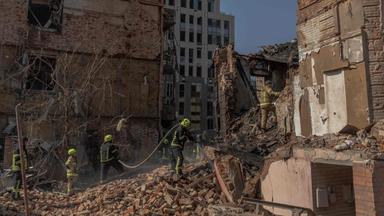 Ukrainische Rettungskräfte arbeiten an einem schwer beschädigtem Gebäude.