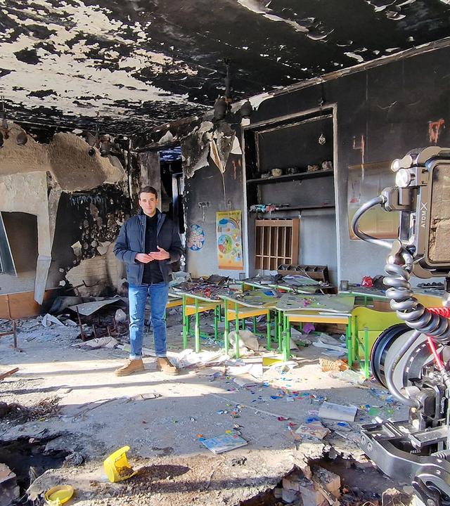 logo!-Reporter Sherif steht in einer zerstörten Schule in der Ukraine