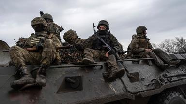 Ukrainische Soldaten fahren mit einem Panzer in Richtung Frontlinie.