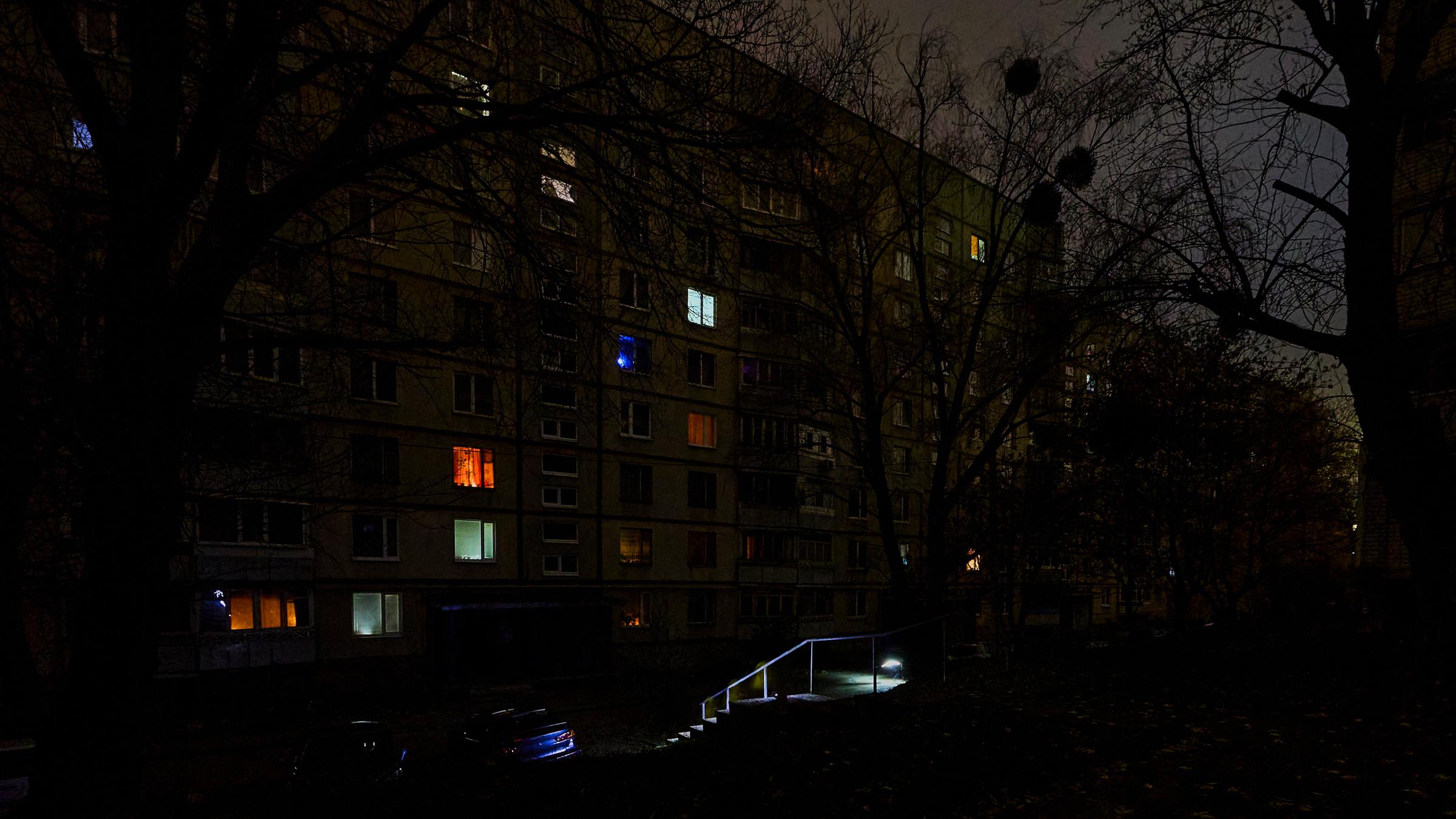 Menschen gehen mit Taschenlampen auf einer dunklen Straße während eines Stromausfalls, der durch russische Bombardements in der vergangenen Nacht verursacht wurde, in Charkiw, Nordostukraine, am 08.11.2025, während der anhaltenden russischen Invasion.