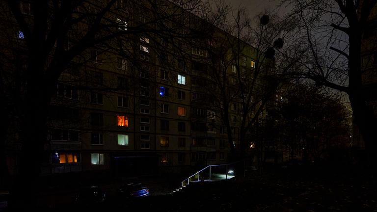 Menschen gehen mit Taschenlampen auf einer dunklen Straße während eines Stromausfalls, der durch russische Bombardements in der vergangenen Nacht verursacht wurde, in Charkiw, Nordostukraine, am 08.11.2025, während der anhaltenden russischen Invasion.