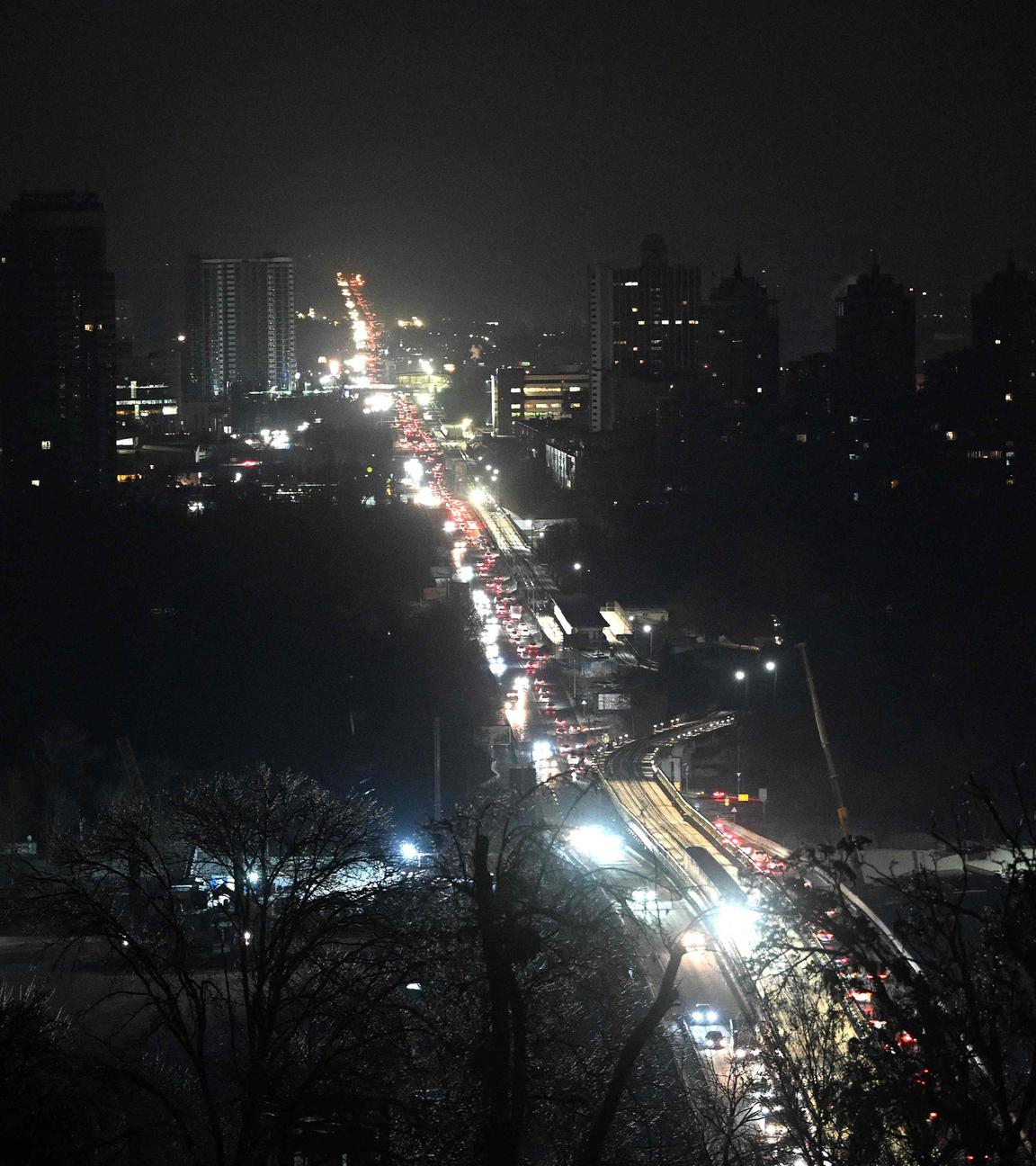 Ukraine, Kiew: Autos fahren im dunkeln. Gebäude haben keinen Strom und sind schwarz.