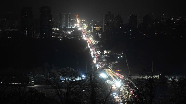 Ukraine, Kiew: Autos fahren im dunkeln. Gebäude haben keinen Strom und sind schwarz.