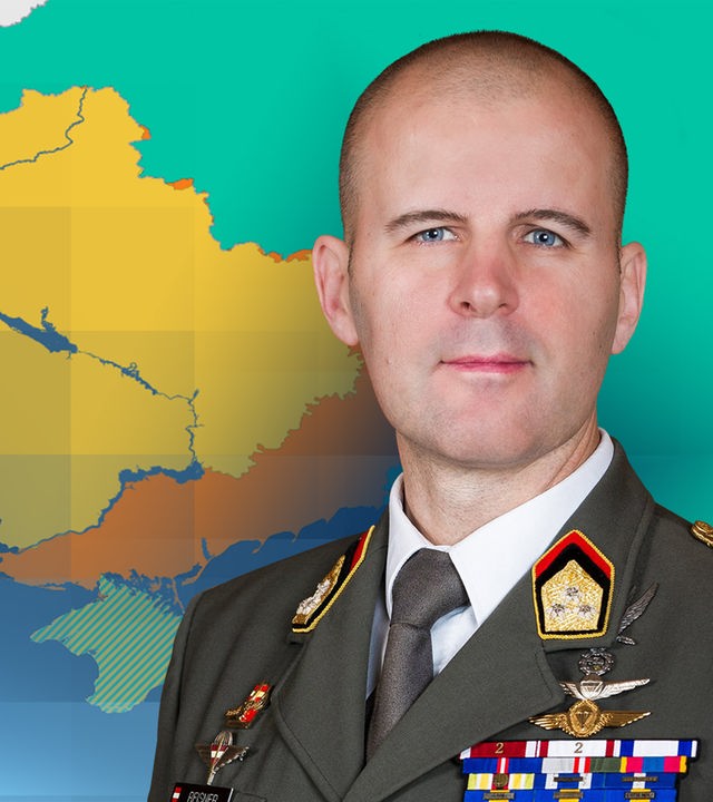Oberst  Markus Reisner in ordenversehrter Militäruniform. Als Bildhintergrund ist eine Karte der Ukraine zu sehen, bei der der Frontverlauf orange hervorgehoben ist.