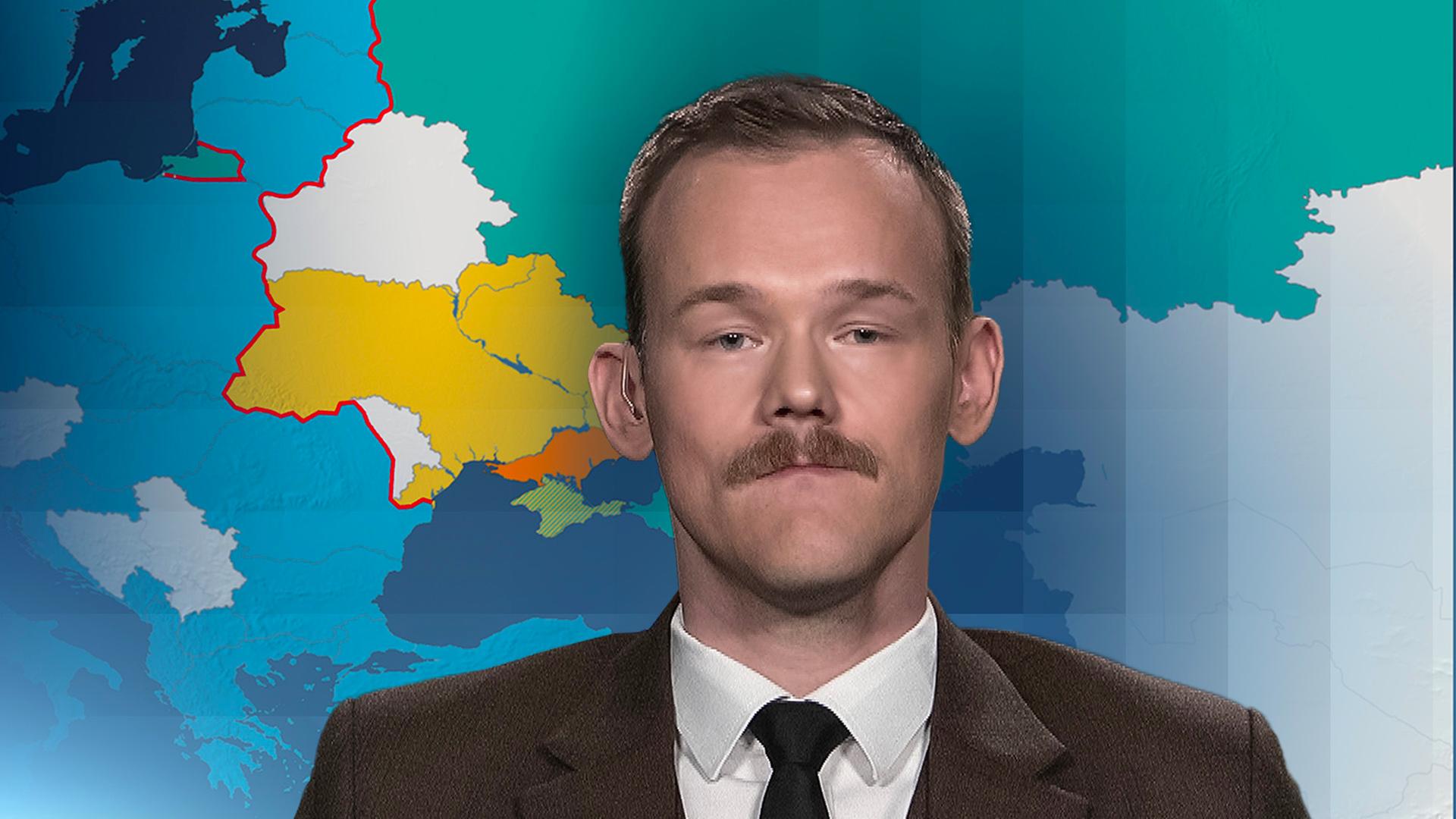 Militärexperte Fabian Hinz vor einer Landkartengrafik