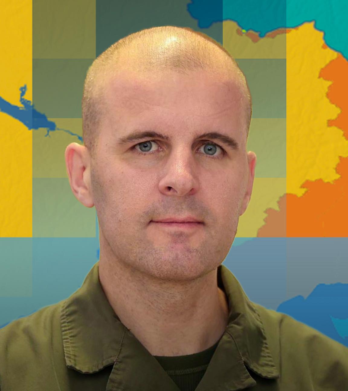 Oberst Markus Reisner ist vor einer Karte der Ukraine mit dem aktuellen Frontverlauf abgebildet.