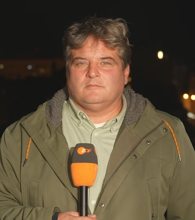ZDF-Reporter Dara Hassanzadeh in Jacke gekleidet nachts in Kiew.