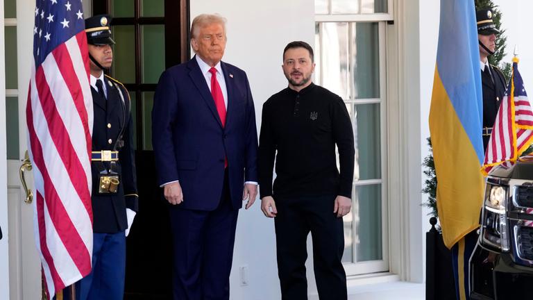 US-Präsident Donald Trump (links) begrüßt den ukrainischen Präsidenten Selenskyi vor dem Weißen Haus in Washington am 28. Februar 2025, neben ihnen stehen Flaggen der USA und Ukraine