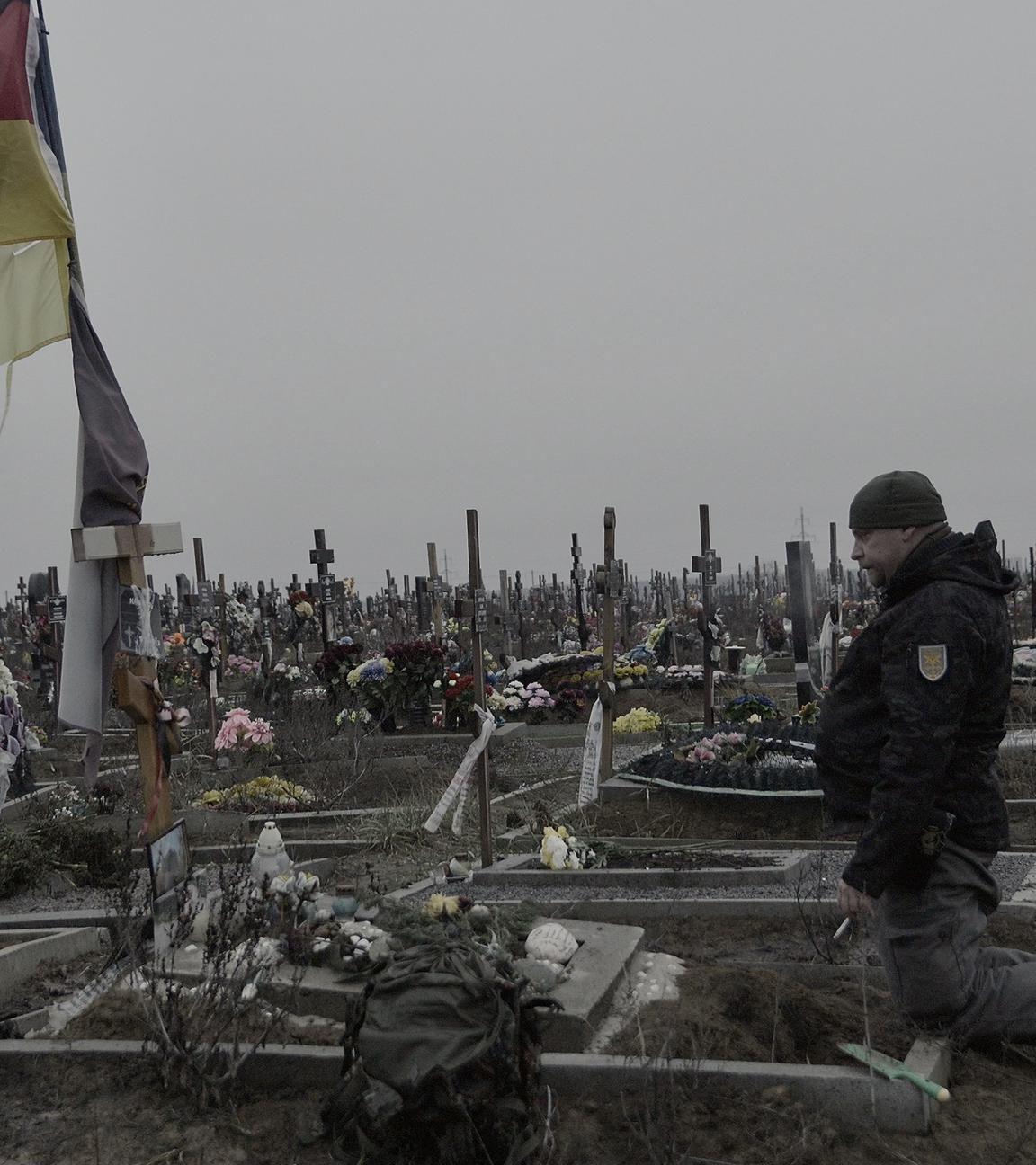 Bruder kniet am Grab von Michael P. in der Ukraine