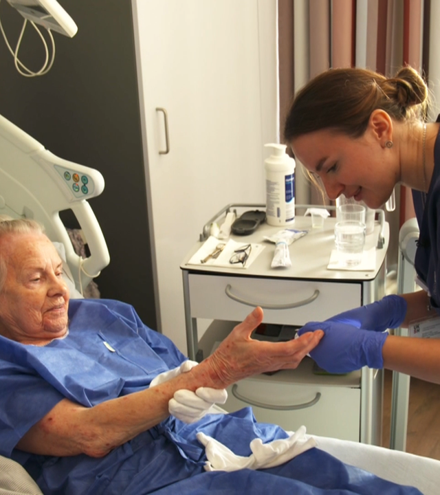 Ukrainische Pflegehilfskraft in der Uniklinik Kiel misst bei einer Patientin Blutzucker