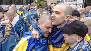 Freigelassene ukrainische Kriegsgefangene umarmen sich nach einem Gefangenenaustausch an einem nicht genannten Ort in der Region Tschernihiw am 15. Mai 2026.