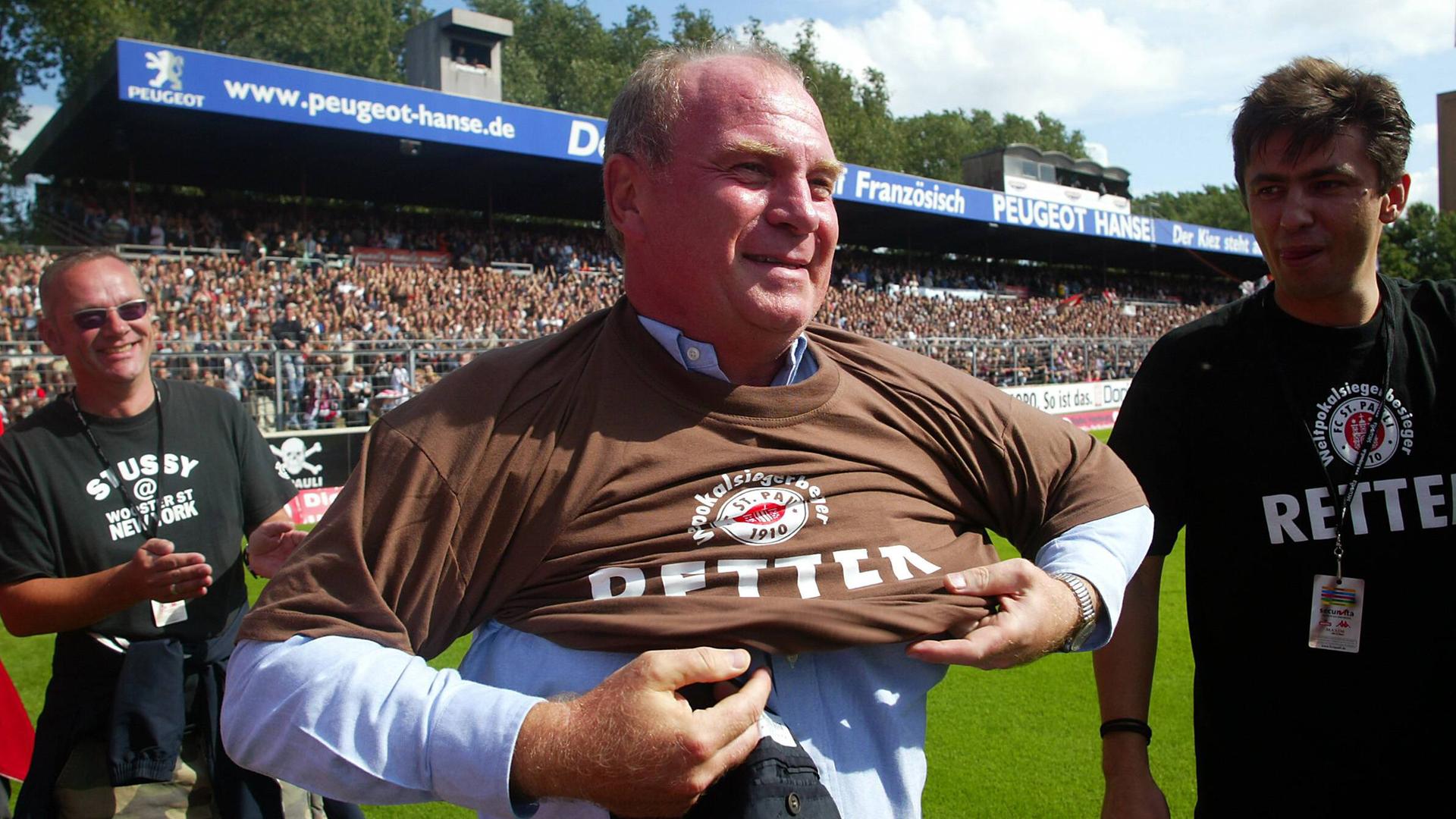 Manager Uli Hoeneß (Bayern) streift sich beim Benefizspiel zur Lizenzsicherung des FC St. Pauli ein Retter T-Shirt über 