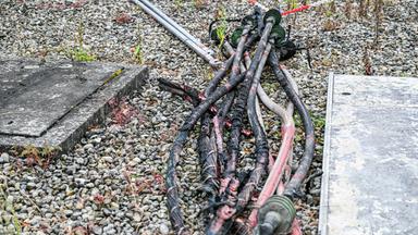 Mehrere verkokelte Kabel liegen nach dem Brand in einem Umspannwerk in Reutlingen auf dem Boden. Die Ermittler gehen von Brandstiftung aus.