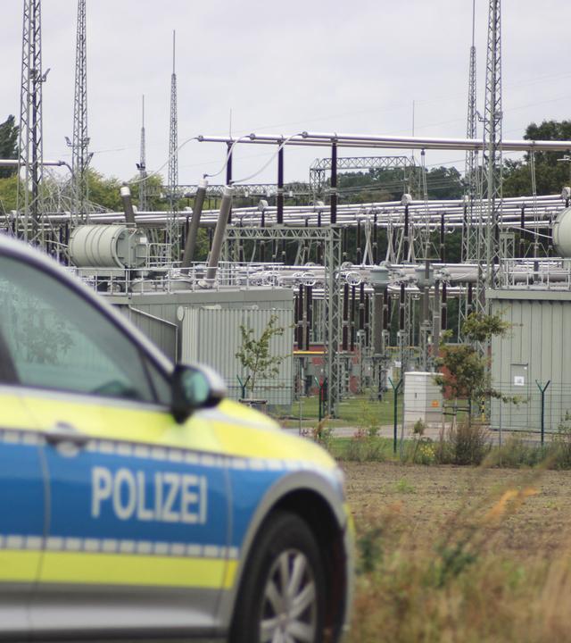 Ein Streifenwagen steht an einer Zufahrt zu einem Umspannwerk in Ganderkesee im niedersächsischen Landkreis Oldenburg