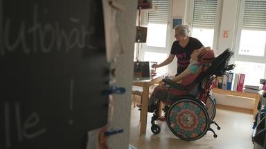 Eine Mutter kümmert sich um ihre pflegebedürftige Tochter