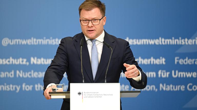 Carsten Schneider, Bundesminister für Umwelt, vor einem Pult und stellt Details zu der neuen Elektroauto-Kaufprämie vor.