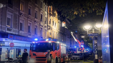 Feuerwehr nachts im Einsatz bei einer Wohnung im höheren Stock nach einem Brand.
