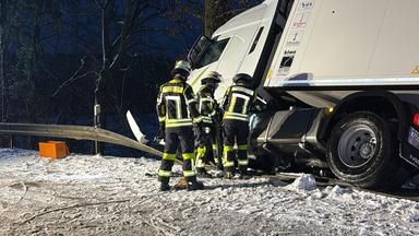 Bayern, Aiglsbach: Ein Lkw hängt nach einem Unfall an der B300 bei Aiglsbach seitlich in der Böschung.