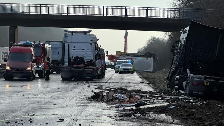 Beschädigte Fahrzeuge, Feuerwehr, Bergungsdienste und Polizei stehen auf der Fahrbahn nach einer durch Glätte ausgelösten Unfallserie mit mehreren Toten und vielen Verletzten auf der A44.