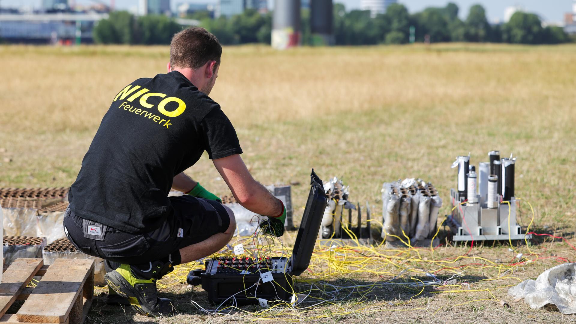 Nordrhein-Westfalen, Düsseldorf: Ein Mitarbeiter der Feuerwerksfirma arbeitet am Unfallort auf den Rheinwiesen.