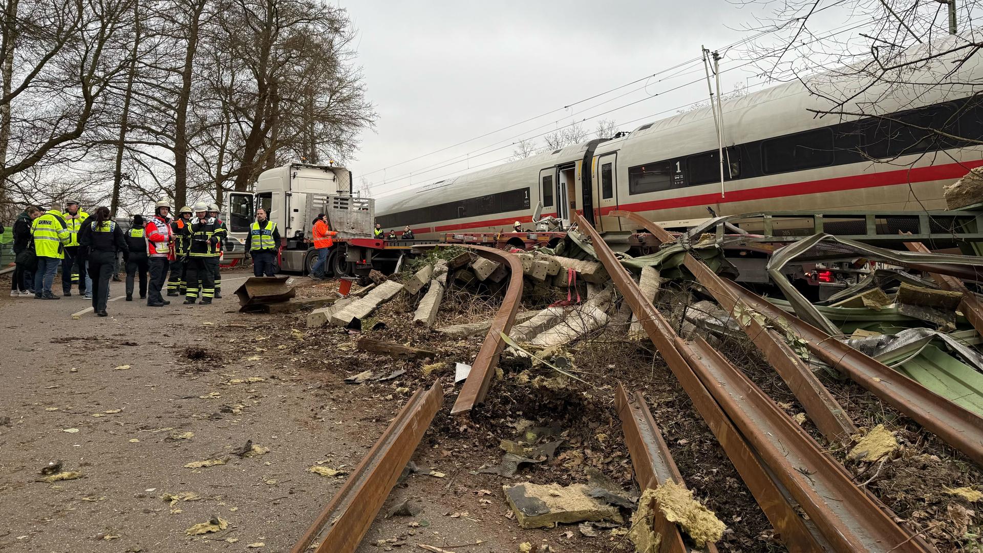 Rettungskräfte arbeiten an der Unfallstelle. In Hamburg-Harburg ist ein ICE gegen einen Sattelzug gefahren.