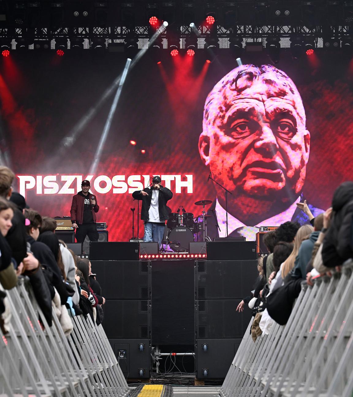 10.04.2026, Ungarn, Budapest: Ein Rap-Duo namens Fekete Kobra tritt während eines regierungskritischen Konzerts mit Dutzenden der populärsten Künstler des Landes auf. Im Hintergrund ist ein überzeichnetes Bild von Viktor Orban, Ministerpräsident von Ungarn, zu sehen.