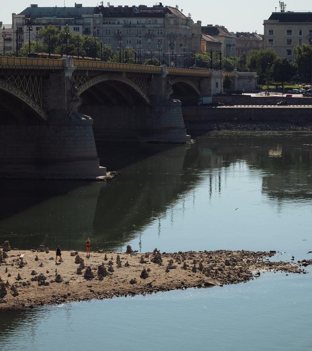 Die Donau in Budapest mit historisch niedrigem Wasserstand, freiliegendem Flussbett und Sandbänken nach anhaltender Hitze und Trockenheit.