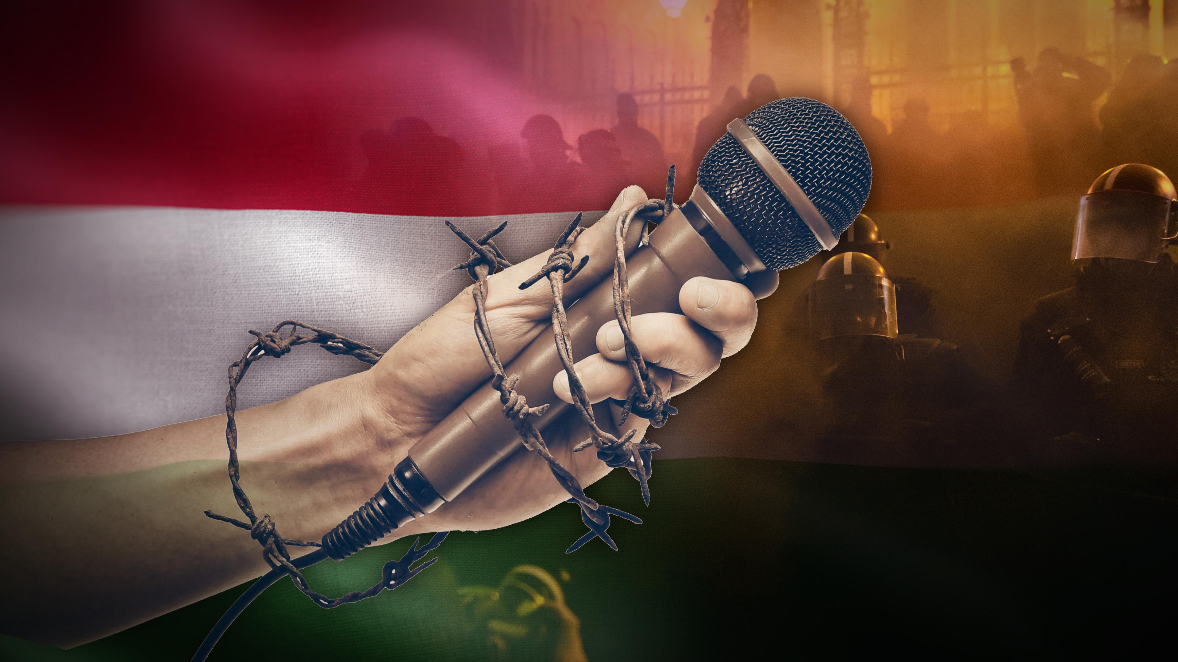 Montage: Eine Hand hält ein Mikrofon. Hand und Mikro sind mit einem Stacheldraht umwickelt. Links im Hintergrund die ungarische Flagge, rechts Polizisten in Schutzausrüstung. 