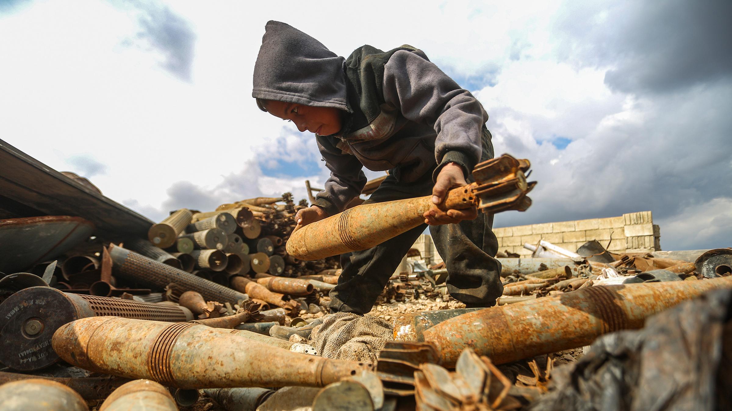 Ein syrischer Junge trägt Munition auf einem Schrottplatz in Hama.