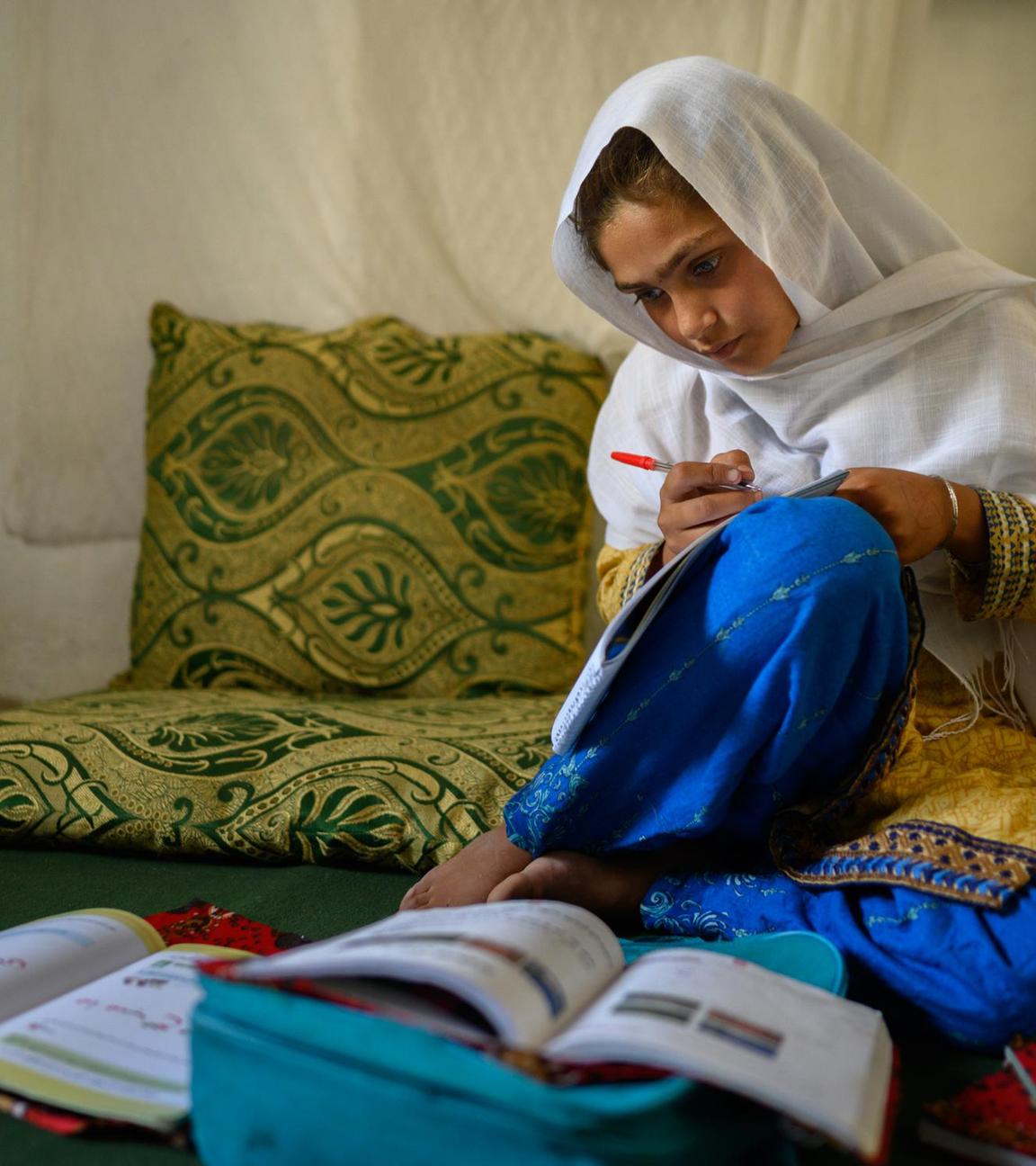 Die zehnjährige Hajira aus der afghanischen Provinz Nangarhar sitzt in einem Haus in einem abgelegenen Dorf östlich von Kabul über Schulbüchern und lernt am 15.12.2025.