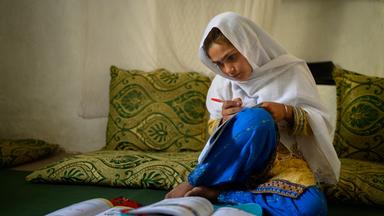 Die zehnjährige Hajira aus der afghanischen Provinz Nangarhar sitzt in einem Haus in einem abgelegenen Dorf östlich von Kabul über Schulbüchern und lernt am 15.12.2025.