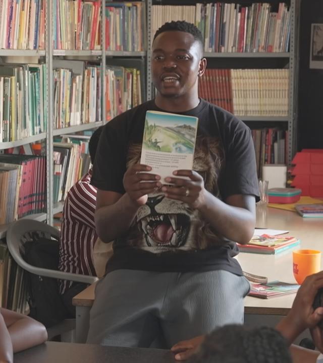 Ein Mann zeigt Kindern ein Buch.